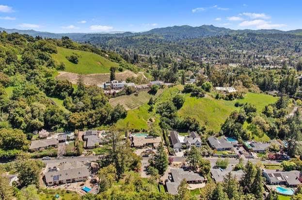 Aerial view of Lafayette hillside homes and wooded ridgelines